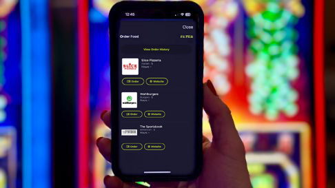 Hand holding phone showing PENN Play App